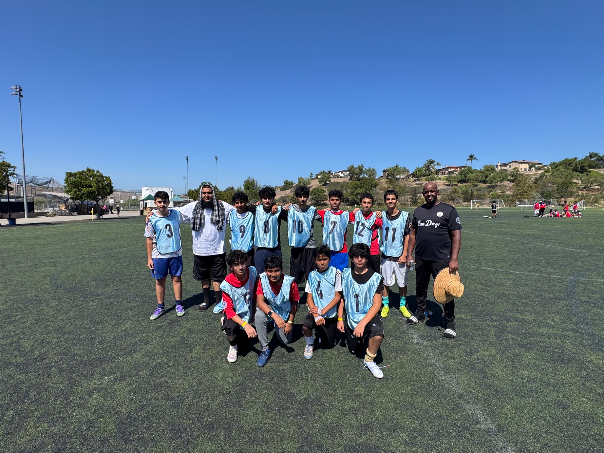 Youth soccer team in blue training bibs with community coaches
